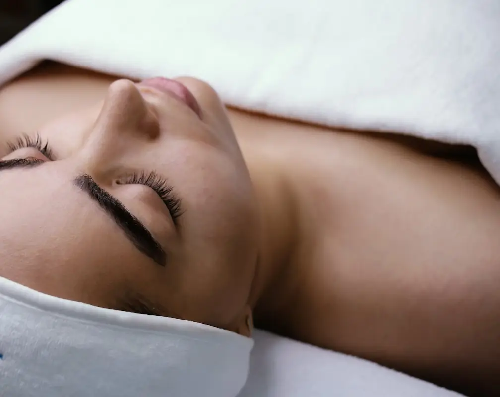 A woman relaxing during a facial treatment