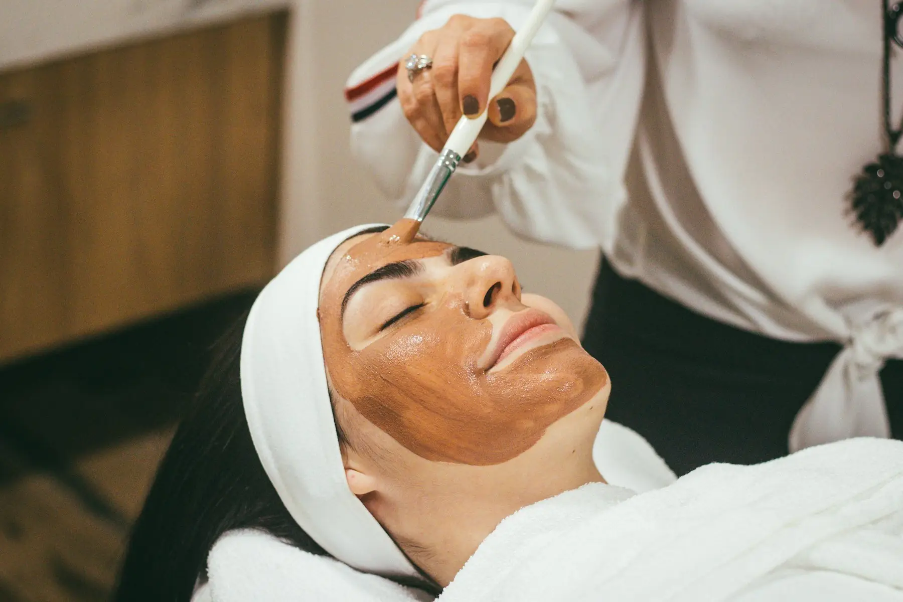 A skin specialist applying a professional peel with a brush